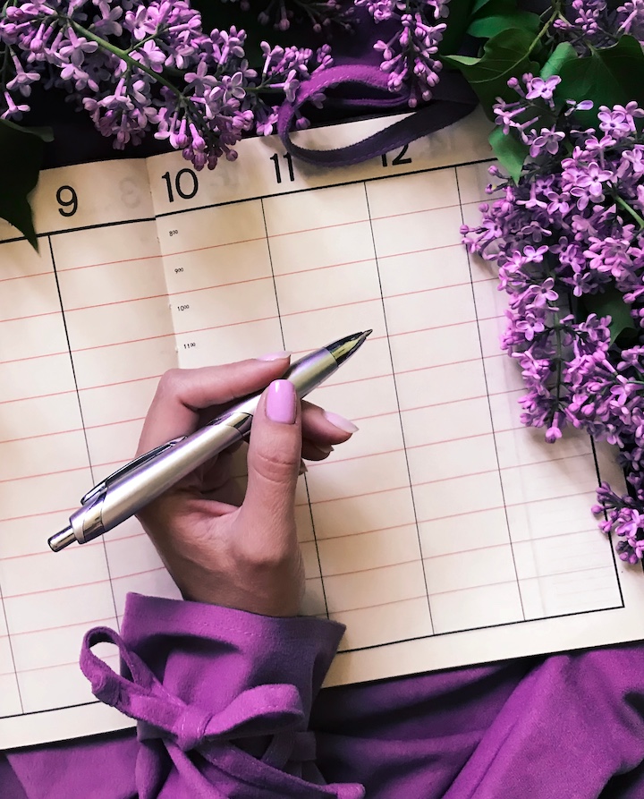hand getting ready to write in a calendar using the diy wedding checklist